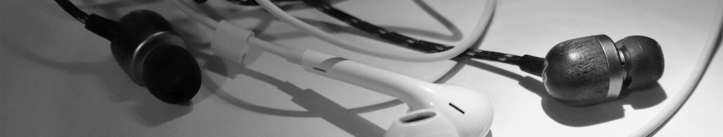 close-up of two black earbuds and two white iPhone earbuds
